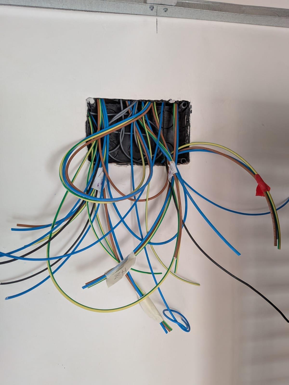 Cables de una caja de derivación etiquetados uno a uno con cinta antes de conectarlos